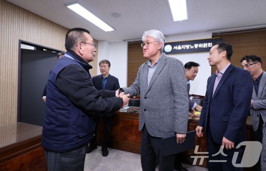 14일 서울 영등포구 서울지방노동위원회에서 열린 특별조정위원회 2차 사후 조정회의에서 서울 시내버스 노사가 임금협상에 극적으로 합의한 뒤 박점곤 서울시버스노동조합 위원장과 김정환 서울시버스사업조합 이사장이 악수를 하고 있다. 2026.1.15/뉴스1 ⓒ News1 박지혜 기자