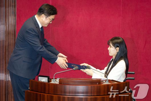 국민의힘 인요한 의원 사퇴로 비례대표 의원직을 승계받은 이소희 의원이 15일 서울 여의도 국회에서 열린 제431회 국회(임시회) 제1차 본회의에서 의원 선서를 마친 후 우원식 국회의장에게 선서문을 전달하고 있다. 2026.1.15/뉴스1 ⓒ News1 유승관 기자