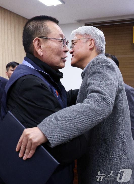 14일 서울 영등포구 서울지방노동위원회에서 열린 특별조정위원회 2차 사후 조정회의에서 서울 시내버스 노사가 임금협상에 극적으로 합의한 뒤 박점곤 서울시버스노동조합 위원장과 김정환 서울시버스사업조합 이사장이 포옹을 하고 있다. 2026.1.15/뉴스1 ⓒ News1 박지혜 기자