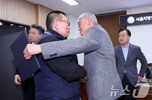 14일 서울 영등포구 서울지방노동위원회에서 열린 특별조정위원회 2차 사후 조정회의에서 서울 시내버스 노사가 임금협상에 극적으로 합의한 뒤 박점곤 서울시버스노동조합 위원장과 김정환 서울시버스사업조합 이사장이 포옹을 하고 있다. 2026.1.15/뉴스1 ⓒ News1 박지혜 기자