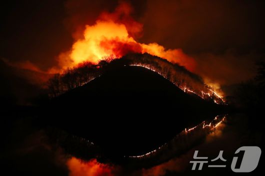 23일 오후 어둠이 짙게 깔린 경북 의성군 의성읍 업리 동사곡지(저수지) 뒤편 야산에 거대한 산불이 확산하고 있다. 2025.3.23/뉴스1 ⓒ News1 공정식 기자