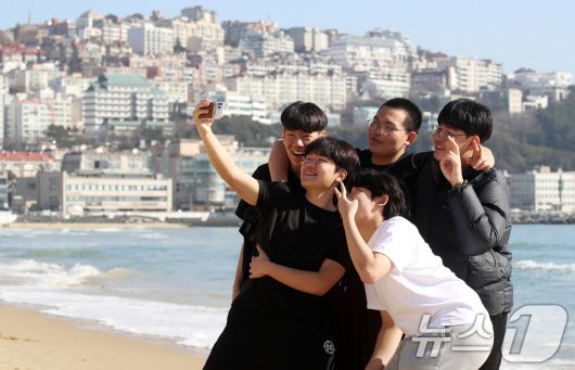 포근한 날씨를 보인 16일 부산 해운대해수욕장에서 반팔 차림을 한 시민들이 셀카를 찍으며 추억을 남기고 있다. 2026.1.16/뉴스1 ⓒ News1 윤일지 기자