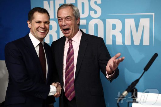 영국 보수당 예비 법무장관이었던 로버트 젠릭(왼쪽) 의원이 15일(현지시간) 나이절 패라지 영국개혁당 대표와 악수하고 있다. 2025.01.15. ⓒ AFP=뉴스1 ⓒ News1 이정환 기자