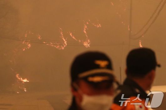 의성 산불 나흘째인 25일 오후 경북 안동시 길안면 백자리에 강풍이 불어 주변 산이 화염에 휩싸인 가운데 소방관계자들이 대피 명령이 내려진 마을 곳곳을 순찰하고 있다. 2025.3.25/뉴스1 ⓒ News1 공정식 기자
