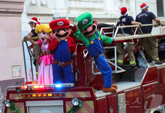 칠레 발파라이소에서 열린 크리스마스 축제에서 '슈퍼마리오' 캐릭터로 분장한 소방관들이 손을 흔들고 있다.2024.12.22 ⓒ 로이터=뉴스1 ⓒ 로이터=뉴스1
