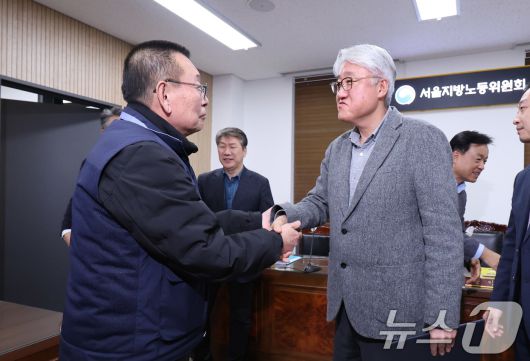 서울 영등포구 서울지방노동위원회에서 열린 특별조정위원회 2차 사후 조정회의에서 서울 시내버스 노사가 임금협상에 극적으로 합의한 뒤 박점곤 서울시버스노동조합 위원장과 김정환 서울시버스사업조합 이사장이 악수를 나누고 있다. 2026.1.15/뉴스1 ⓒ News1 박지혜 기자