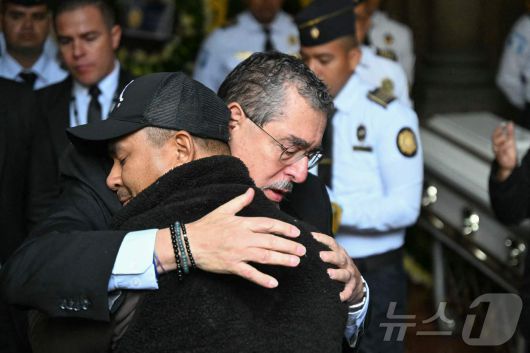 19일(현지시간) 과테말라시티 내무부 청사에서 열린 순직 경찰관 장례식에서 베르나르도 아레발루 과테말라 대통령이 유족을 안아주고 있다. 2026.01.19. ⓒ AFP=뉴스1 ⓒ News1 이정환 기자