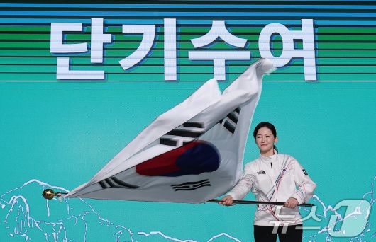 이수경 선수단장이 22일 서울 송파구 올림픽파크텔에서 열린 2026 밀라노코르티나 동계올림픽대회 결단식에서 유승민 대한체육회장에게 수여받은 단기를 흔들고 있다. 2026.1.22/뉴스1 ⓒ News1 김성진 기자