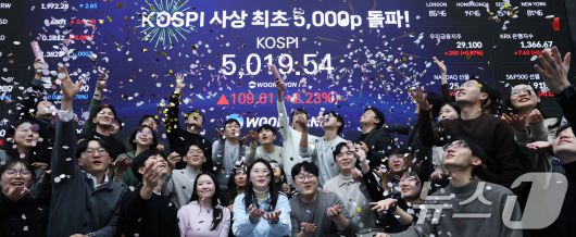 22일 서울 중구 우리은행 본점 딜링룸에서 직원들이 장중 최고가가 찍힌 전광판을 배경으로 코스피 5000 돌파를 축하하고 있다. 2026.1.22/뉴스1 ⓒ News1 오대일 기자