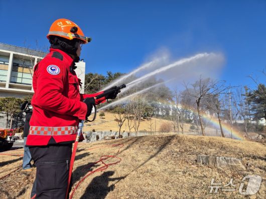 22일 오전 강원 강릉 동부지방산림청에서 산불진화대원이 고압 호스를 이용해 봄철 산불 대응 장비 시연을 펼치자 물줄기 사이로 무지개가 피어오르고 있다.2026.1.22/뉴스1 윤왕근 기자