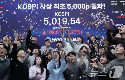 한국 증시가 사상 처음으로 '코스피 5000' 쾌거를 달성한 지난 22일 서울 중구 우리은행 본점 딜링룸에서 직원들이 장중 최고가가 찍힌 전광판을 배경으로 코스피 5000 돌파를 축하하고 있다. 2026.1.22/뉴스1 ⓒ News1 오대일 기자
