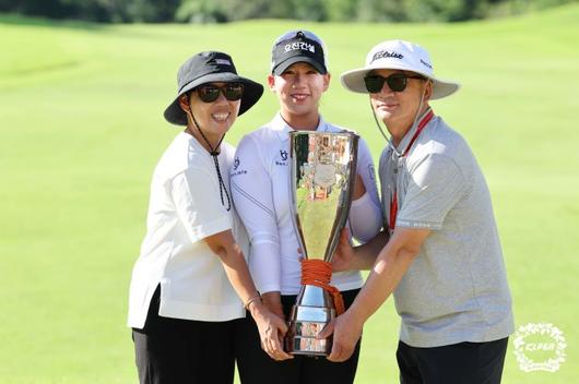 부모님과 함께 우승 트로피를 두고 포즈를 취한 홍지원. [사진= KLPGA]