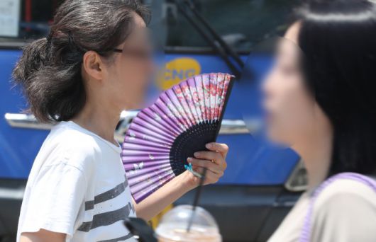 [서울=뉴스핌] 최지환 기자 = 서울 낮 최고기온이 35도까지 올라가며 첫 폭염주의보가 내려진 19일 오후 서울 종로구 광화문네거리에서 한 시민이 부채를 부치며 이동하고 있다. 2024.06.19 choipix16@newspim.com