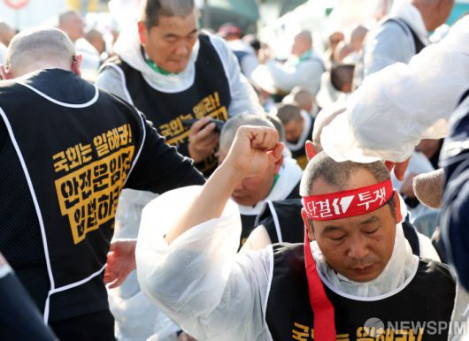 [서울=뉴스핌] 최지환 기자 =11일 오후 서울 여의도 국회 앞에서 열린 '국민안전 사수! 안전운임제 입법 촉구! 화물노동자 100인 삭발 결의대회'에서 화물연대본부 노조원들이 안전운임제 입법을 촉구하며 삭발식을 하고 있다. 2024.11.11 choipix16@newspim.com