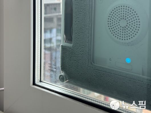 [서울=뉴스핌] 김정인 기자 =  에코백스 '윈봇 W2 옴니'가 아파트 창문 청소를 하고 있는 모습. 모서리 청소가 아쉽다. 2025.05.09 kji01@newspim.com