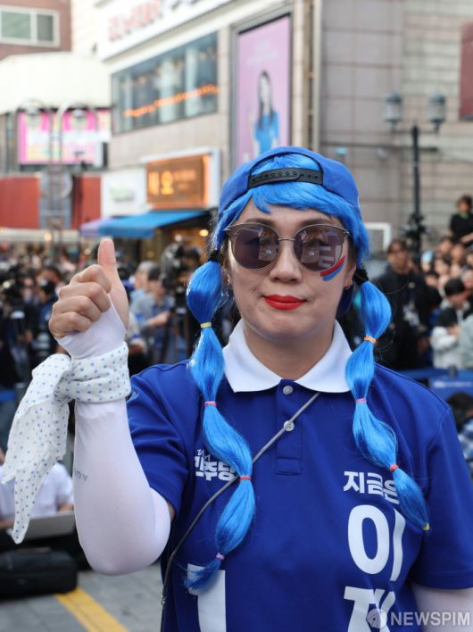 [천안=뉴스핌] 김학선 기자 = 25일 충남 천안시 신부문화거리에서 이재명 더불어민주당 대선후보 지지자업지를 들어 보이고 있다. 2025.05.25 yooksa@newspim.com