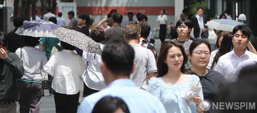 [서울=뉴스핌] 이형석 기자 = 무더위가 이어지며 체감온도가 33도를 넘나드는 1일 오후 서울 여의도 인근에서 시민들이 양산을 쓰고 발걸음을 재촉하고 있다. 2025.07.01 leehs@newspim.com