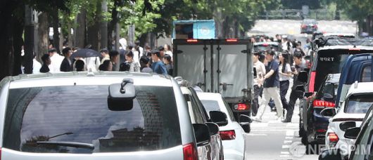 [서울=뉴스핌] 이형석 기자 = 무더위가 이어지며 체감온도가 33도를 넘나드는 1일 오후 서울 여의도 인근에서 지열과 도로를 지나는 차량의 열기에 시민들이 일그러져 보이고 있다. 2025.07.01 leehs@newspim.com