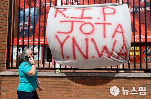 [리버풀 로이터 =뉴스핌] 박상욱 기자 = 3일 리버풀 안필드 스타디움 외곽에서 한 여성이 디오구 조타를 추모하는 현수막 앞을 지나가고 있다. 2025.7.3 psoq1337@newspim.com