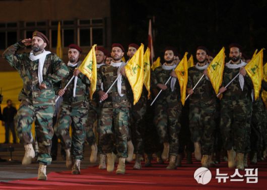 지난 2019년 5월 31일(현지시간) 정당 깃발 들고 행진하는 레바논 팔레스타인 무장 정파 헤즈볼라 대원들의 모습. [사진=로이터 뉴스핌]