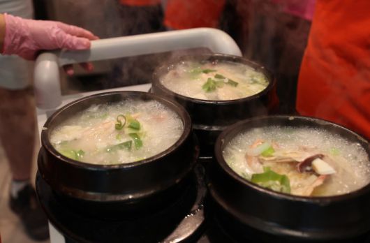 [서울=뉴스핌] 이호형 기자 =초복을 하루 앞둔 14일 서울 중구의 한 삼계탕전문점에서 직원이  삼계탕을 나르고 있다.  2024.07.14 leemario@newspim.com