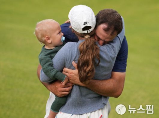 [포트러시 로이터 =뉴스핌] 박상욱 기자 = 셰플러가 21일 디오픈 챔피언십 최종일 18번홀에서 아내 메러디스 셰플러, 아들 베넷과 우승의 기쁨을 나누고 있다. 2025.7.21 psoq1337@newspim.com
