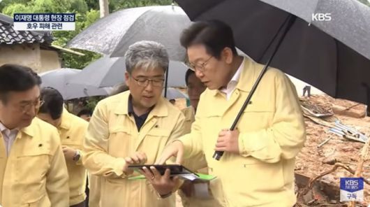 이재명 대통령이 21일 경상남도 산청군 집중호우 피해 현장을 방문해 브리핑을 듣고 있다. 2025.7.21 [사진=KBS 캡처]