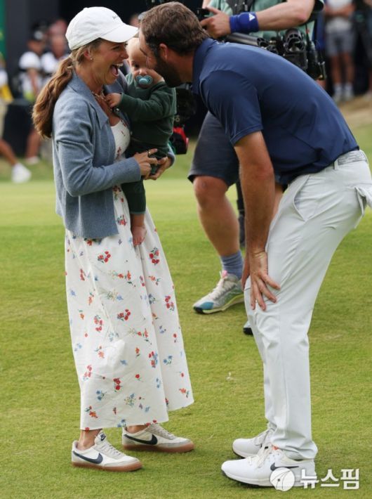 [포트러시 로이터 =뉴스핌] 박상욱 기자 = 셰플러가 21일 디오픈 챔피언십 최종일 18번홀에서 아내 메러디스 셰플러, 아들 베넷과 우승의 기쁨을 나누고 있다. 2025.7.21 psoq1337@newspim.com
