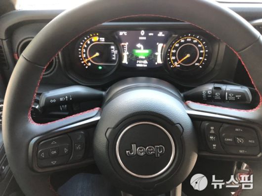 [서울=뉴스핌] 조수빈 기자 = 지프 랭글러 투스카데로 스티어링휠. 아날로그한 계기판과 물리 버튼이 특징이다. [사진=조수빈 기자] 2025.08.14 beans@newspim.com