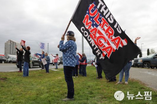 2025년 8월 15일 미국 알래스카주 앵커리지에서 한 시위자가 도널드 트럼프 대통령을 지지하는 집회에서 "이곳은 극단적인 MAGA 국가다"라고 쓰인 깃발을 들고 있다. [사진=로이터 뉴스핌]