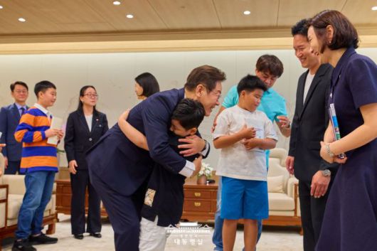 이재명 대통령이 김혜경 여사와 함께 4일 용산 대통령실로 어린이들과 가족을 초청한 행사에서 어린이들을 따뜻이 앉아 주면서 격려하고 있다. [사진=대통령실]