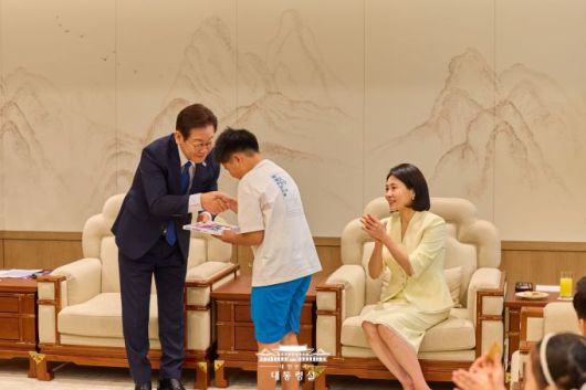 이재명 대통령과 김혜경 여사가 4일 용산 대통령실로 어린이들과 가족을 초청한 행사에서 책을 선물하고 있다. [사진=대통령실]