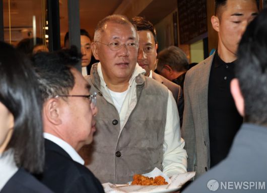 [서울=뉴스핌] 최지환 기자 = 정의선 현대차그룹 회장이 30일 오후 서울 강남구 삼성역 인근 깐부치킨 매장에서 젠슨 황 엔비디아 최고경영자(CEO), 삼성전자 이재용 회장과 치킨 회동 중 밖으로 나와 시민들에게 치킨을 나눠주고 있다. 2025.10.30 choipix16@newspim.com