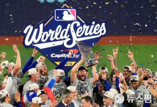 [토론토 로이터=뉴스핌] 장환수 스포츠전문기자= LA 다저스 선수들이 2일 월드시리즈 7차전에서 승리, 2년 연속 챔피언에 오른 뒤 환호하고 있다. 올 시즌을 끝으로 은퇴하는 전설 클레이턴 커쇼가 우승컵을 안고 있다. 2025.11.03 zangpabo@newspim.com