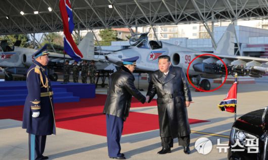 [서울=뉴스핌] 지난 11월 28일 강원도 원산 갈마비행장에서 열린 북한 공군 창설 80주년 행사에 참석한 김정은 국무위원장이 김광혁 공군사령관과 악수하고 있다. 왼쪽은 정치위원 엄주호(공군 중장). 뒤편으로 전투기에 장착된 공대지 미사일이 드러나는데, 우리 군도 보유한 독일산 '타우러스'와 유사한 모양새다. [사진=노동신문 홈페이지] 2025.12.01