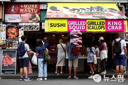 일본 도쿄 츠키지 시장의 한 가게에서 외국인 관광객들이 음식을 먹고 있다. [사진=로이터 뉴스핌]