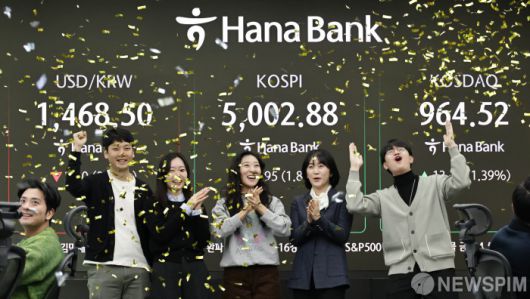 [서울=뉴스핌] 양윤모 기자 = 22일 오전 코스피가  5000 을 돌파하자 서울 중구 하나은행본점 딜링룸에서 직원들이 환호하고 있다. 2026.01.22 yym58@newspim.com