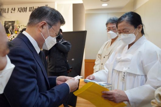 문재인 대통령이 17일 오전 서울 종로구 서울대병원 장례식장에 마련된 고(故) 백기완 통일문제연구소장 빈소를 조문, 유족으로부터 고인의 저서를 건네받고 있다. 연합뉴스