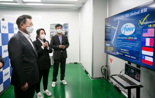 문재인 대통령이 18일 오후 전북 군산시 코로나19 백신접종용 최소잔여형(LDS) 주사기 생산시설인 풍림파마텍을 방문해 관계자로부터 생산라인에 대한 설명을 듣고 있다. 연합뉴스