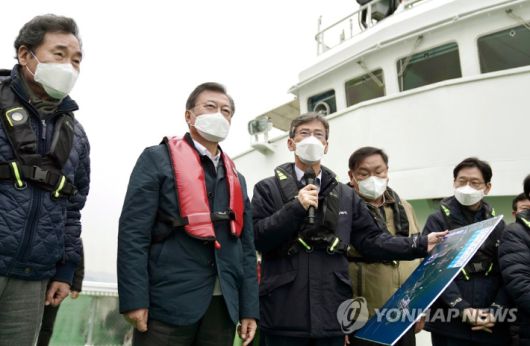 문재인 대통령이 25일 부산에서 열린 '동남권 메가시티 구축 전략 보고'에 참석, 가덕도 공항 예정지를 어업지도선을 타고 시찰하며 이병진 부산시장 권한대행으로부터 관련 보고를 청취하고 있다.  연합뉴스