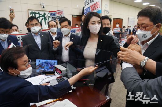 지난 19일 오후 서울 여의도 국회 문화체육관광위원회 전체회의에서 국민의힘 의원들이 언론중재법 개정안 통과시키려는 도종환 위원장의 회의 진행를 막아서고 있다. 윤창원 기자