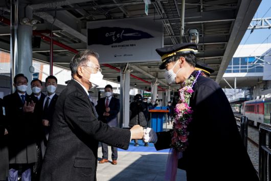 문재인 대통령이 28일 울산 태화강역에서 열린 동남권 4개 철도건설사업 개통식에서 광역전철 기관사들에게 꽃목걸이를 걸어준 뒤 인사하고 있다. 연합뉴스