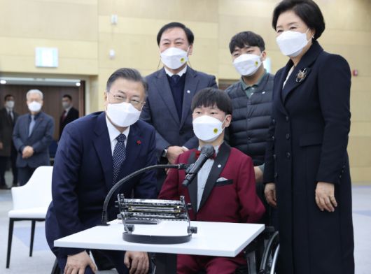 문재인 대통령과 김정숙 여사가 29일 충남 공주시 공주대학교 옥룡캠퍼스에서 열린 공주대학교 부설 특수학교 설립 간담회를  마친 뒤 표형민 맑은소리 하모니카 앙상블 대원 등과 기념촬영을 하고 있다. 연합뉴스