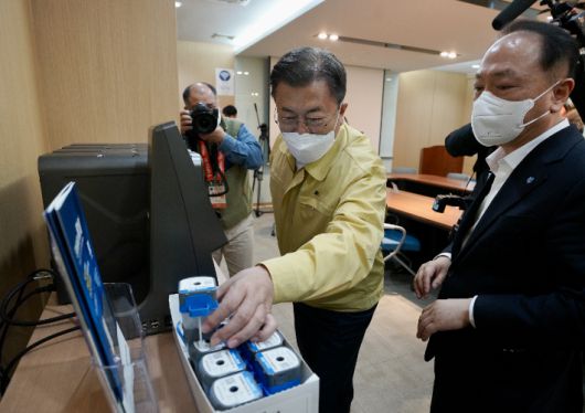 코로나19 자가 진단키트를 생산하는 오송 공장을 찾아 실시간 유전자 증폭 장치를 살펴보고 있는 문재인 대통령. 연합뉴스