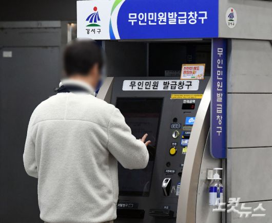 지난주 금요일부터 사흘간 멈춰 섰던 정부행정전산망이 복구된 20일 서울시내 지하철역에서 한 시민이 무인민원발급기를 이용하고 있다. 황진환 기자