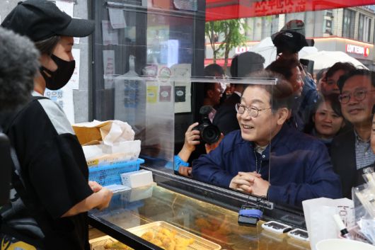 민심을 듣는 '골목골목 경청 투어'를 시작한 더불어민주당 이재명 대선 후보가 1일 경기도 북부 접경지역인 포천의 한 치킨집에서 치킨을 사먹으며 상인과 대화하고 있다. 연합뉴스