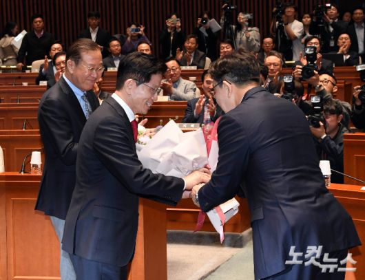 국민의힘 김문수 대선후보가 9일 국회에서 열린 의원총회에 참석해 권성동 원내대표로부터 꽃다발을 받고 있다. 황진환 기자