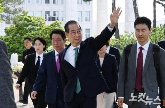 한덕수 무소속 대선 예비후보가 지난 8일 국회 강변서재 앞뜰에서 열린 김문수 국민의힘 대통령 후보와 회동에 참석하며 지지자들에게 손을 들어 인사하고 있다. 황진환 기자