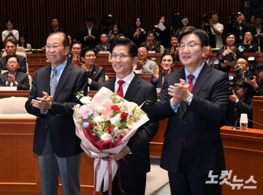 국민의힘 김문수 대선후보가 9일 국회에서 열린 의원총회에 참석해 꽃다발을 받은 후 권영세 비대위원장, 권성동 원내대표와 기념촬영 하고 있다. 황진환 기자