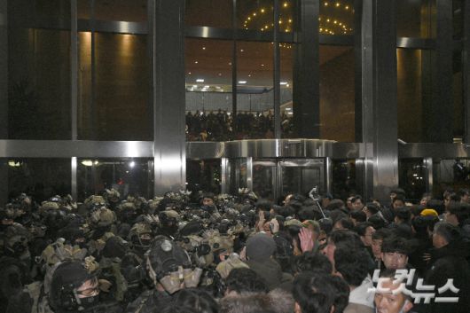 지난해 12월 3일 밤 윤석열 전 대통령이 비상계엄을 선포한 가운데 서울 여의도 국회에서 경내로 진입하려는 계엄군과 저지하려는 시민 및 국회 관계자들이 대치하고 있다. 박종민 기자